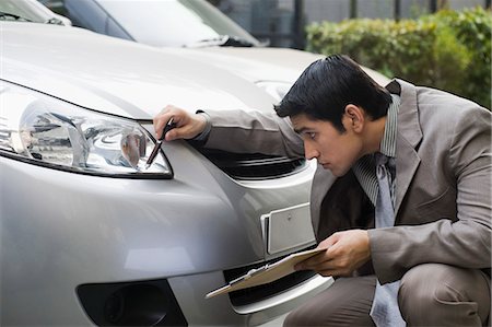 suit squat businessman - Insurance adjuster inspecting a car Stock Photo - Premium Royalty-Free, Code: 630-06722246