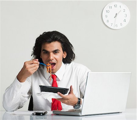 Businessman eating noodles at the desk Foto de stock - Sin royalties Premium, Código: 630-06722295