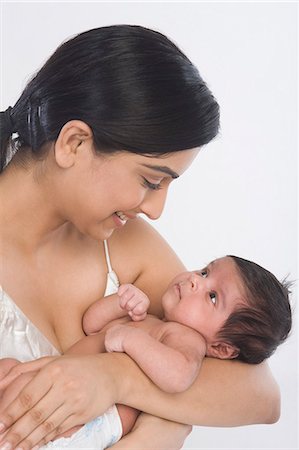 photos of mom carrying a new born baby - Woman carrying her baby and smiling Stock Photo - Premium Royalty-Free, Code: 630-06722581