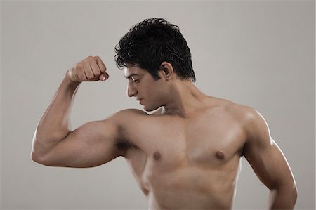 Muscular man flexing his biceps Stock Photo - Premium Royalty-Free, Code: 630-06722677