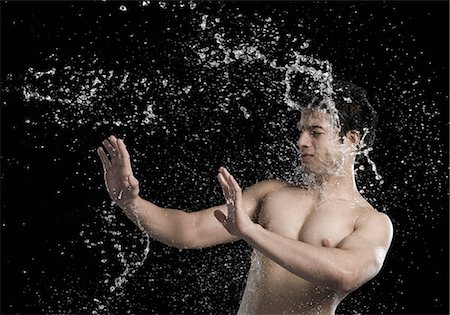simsearch:630-06722667,k - Bare chested man splashed with water Foto de stock - Royalty Free Premium, Número: 630-06722697
