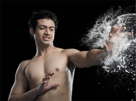 Bare chested man splashed with water Stock Photo - Premium Royalty-Free, Code: 630-06722706