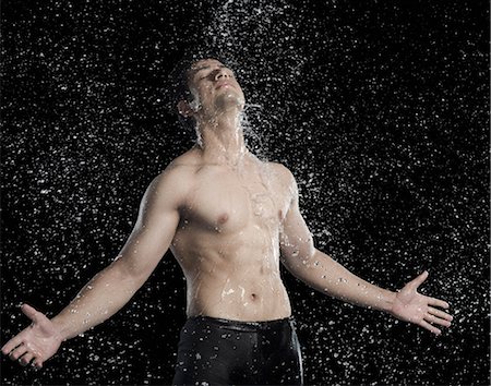 simsearch:630-06722685,k - Bare chested man splashed with water Foto de stock - Royalty Free Premium, Número: 630-06722701