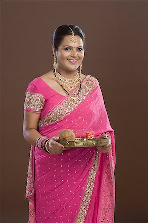 Portrait of a woman in sari holding religious offering Stock Photo - Premium Royalty-Free, Code: 630-06722863