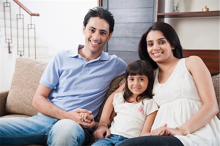 relaxing in home on couch happy couple living room - Portrait of a girl sitting with her parents Stock Photo - Premium Royalty-Free, Code: 630-06722995