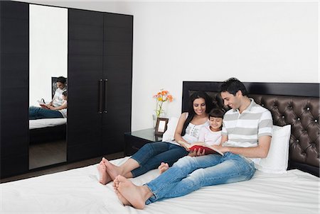 simsearch:630-06723130,k - Couple teaching their daughter in the bedroom Foto de stock - Royalty Free Premium, Número: 630-06723084