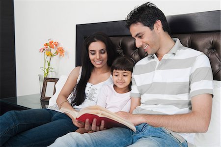 Couple teaching their daughter in the bedroom Stock Photo - Premium Royalty-Free, Code: 630-06723085