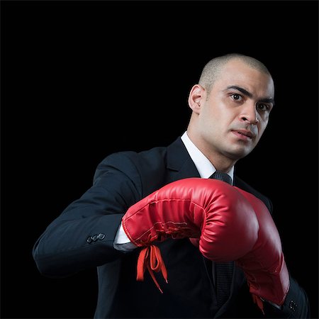 Portrait of a businessman wearing a boxing glove Stock Photo - Premium Royalty-Free, Code: 630-06723162