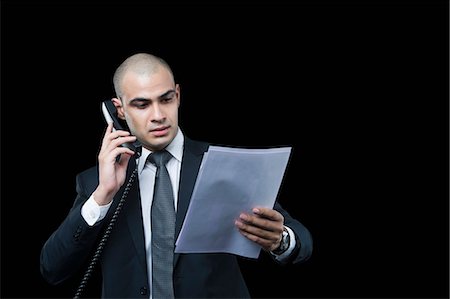 simsearch:630-06723241,k - Businessman talking on the telephone and looking at a document Stock Photo - Premium Royalty-Free, Code: 630-06723204