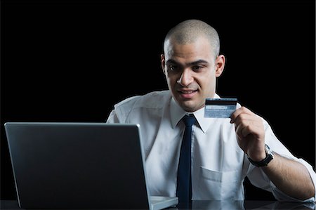 simsearch:630-06723241,k - Close-up of a businessman holding a credit card and using a laptop Stock Photo - Premium Royalty-Free, Code: 630-06723245