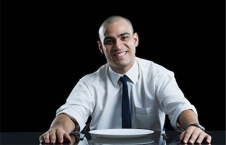 simsearch:630-06723241,k - Businessman sitting at a dining table and smiling Stock Photo - Premium Royalty-Free, Code: 630-06723242