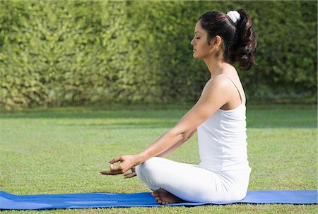 Woman meditating in a park Stock Photo - Premium Royalty-Free, Code: 630-06723398