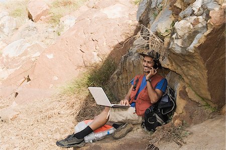 sitting in sport shorts - Hiker sitting on a rock and talking on a mobile phone Stock Photo - Premium Royalty-Free, Code: 630-06723497