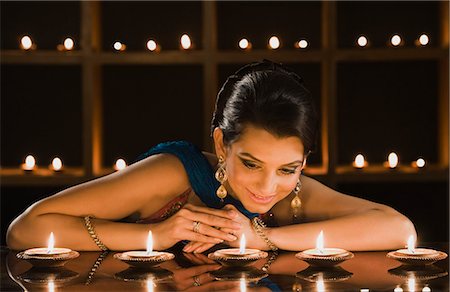 diwali lights photography - Woman looking at oil lamps and smiling Stock Photo - Premium Royalty-Free, Code: 630-06723536