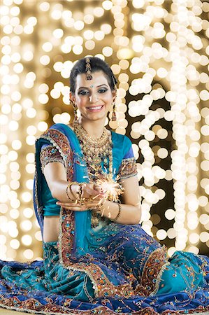 Woman celebrating Diwali festival with a sparkler Stock Photo - Premium Royalty-Free, Code: 630-06723563