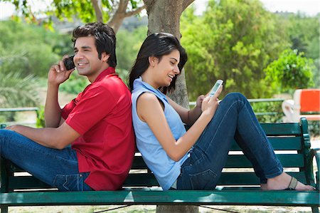 simsearch:630-06722722,k - Couple using mobile phones in a park, Japanese Park, Rohini, Delhi, India Foto de stock - Sin royalties Premium, Código: 630-07071237