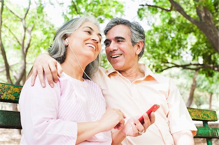 picture of two people on a park bench - Mature couple listening to music with an MP3 player and smiling, Lodi Gardens, New Delhi, India Stock Photo - Premium Royalty-Free, Code: 630-07071307