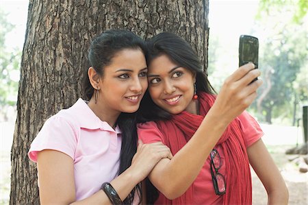 Friends taking a picture of themselves with a mobile phone, Lodi Gardens, New Delhi, Delhi, India Foto de stock - Sin royalties Premium, Código: 630-07071341