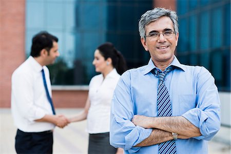 Portrait of a businessman with his colleagues standing behind him Stock Photo - Premium Royalty-Free, Code: 630-07071524