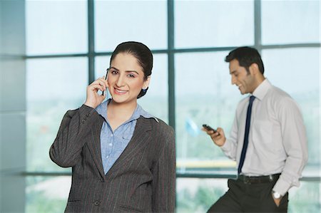 simsearch:630-07071595,k - Businesswoman talking on a mobile phone with her colleague in the background Stockbilder - Premium RF Lizenzfrei, Bildnummer: 630-07071561