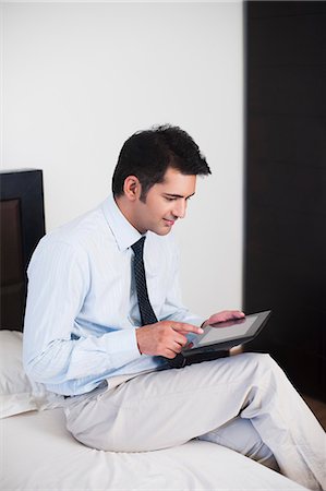 simsearch:630-07071629,k - Businessman using a digital tablet on the bed Foto de stock - Royalty Free Premium, Número: 630-07071635