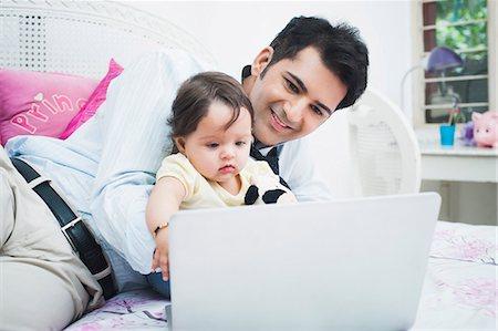 father son bedroom - Businessman with his baby working on a laptop Stock Photo - Premium Royalty-Free, Code: 630-07071647