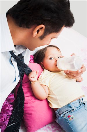 father baby bed - Businessman feeding his baby Stock Photo - Premium Royalty-Free, Code: 630-07071641