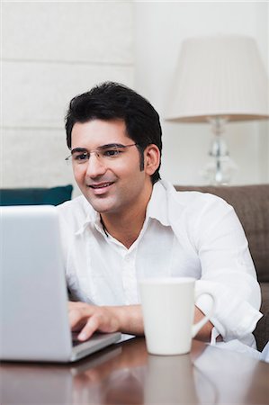 eyeglasses for indian men - Man working on a laptop Stock Photo - Premium Royalty-Free, Code: 630-07071669