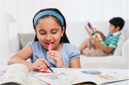 Girl reading books with her brother in the background Foto de stock - Sin royalties Premium, Código: 630-07071759