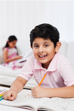 drawings of a girl and boy - Boy making drawings with his sister in the background Stock Photo - Premium Royalty-Free, Code: 630-07071750
