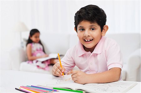 drawings of a girl and boy - Boy making drawings with his sister in the background Stock Photo - Premium Royalty-Free, Code: 630-07071751