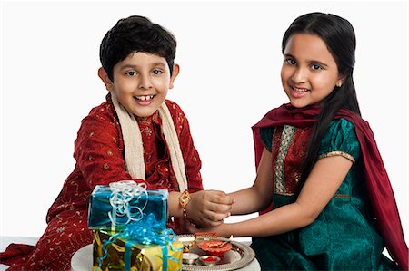 rakhi - Girl tying rakhi on her brother wrist Stock Photo - Premium Royalty-Free, Code: 630-07071821