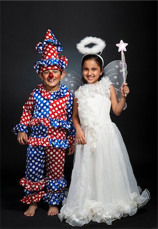 friends black background - Boy imitating like a clown and girl imitating like a fairy Stock Photo - Premium Royalty-Free, Code: 630-07071833