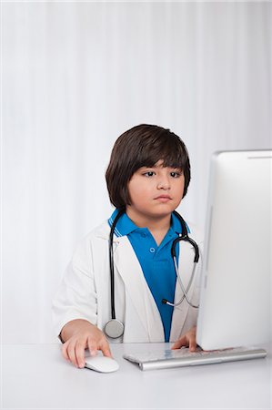 play doctor - Boy using a desktop computer and imitating like a doctor Stock Photo - Premium Royalty-Free, Code: 630-07071840