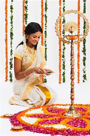 South Indian woman making a rangoli of flowers at Onam Stock Photo - Premium Royalty-Free, Code: 630-07071874