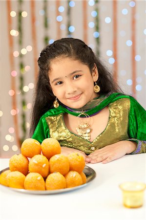 Girl smiling and a plate of laddoo on Diwali Stock Photo - Premium Royalty-Free, Code: 630-07071957