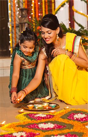 Woman and her daughter decorating rangoli with oil lamps on Diwali Stock Photo - Premium Royalty-Free, Code: 630-07072012