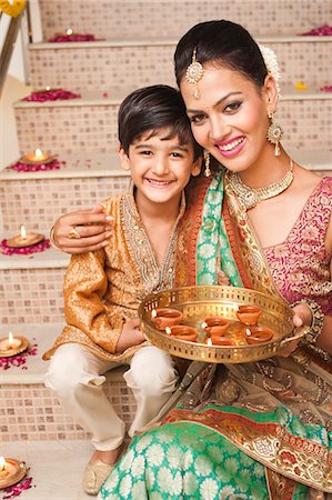 family holiday celebration - Woman and her son decorating with oil lamps on Diwali Photographie de stock - Premium Libres de Droits, Code: 630-07072045