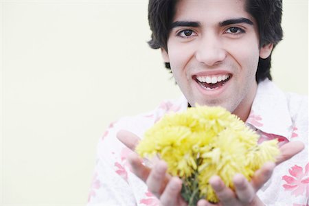Portrait of a young man holding flowers Stock Photo - Premium Royalty-Free, Code: 630-01075570