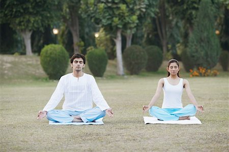 Young couple doing yoga in the garden Stock Photo - Premium Royalty-Free, Code: 630-01075620