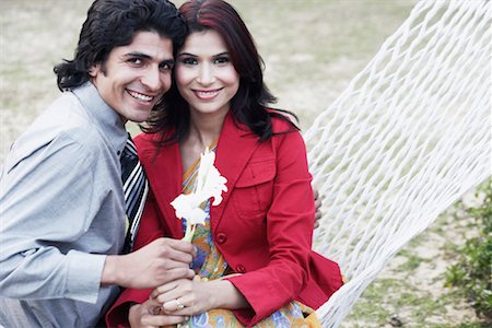 Close-up of a young couple sitting in a hammock Stock Photo - Premium Royalty-Free, Code: 630-01075958