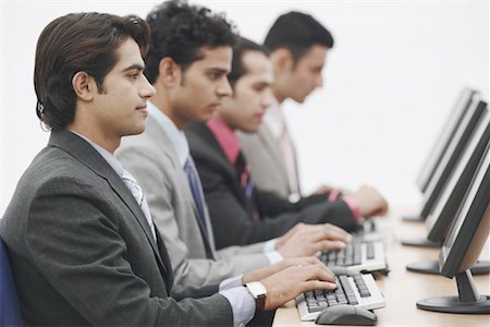 simsearch:630-01076251,k - Side profile of four businessmen sitting in front of computers Stock Photo - Premium Royalty-Free, Code: 630-01076255
