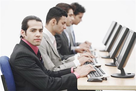 simsearch:630-01128454,k - Side profile of four businessmen sitting in front of computers Stock Photo - Premium Royalty-Free, Code: 630-01076253