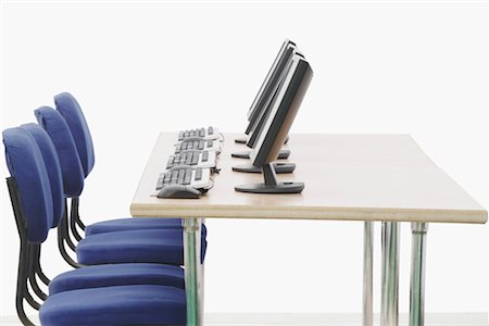 Computer on a table in front of chairs Stock Photo - Premium Royalty-Free, Code: 630-01076271