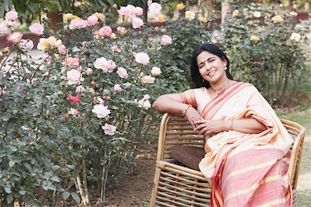 Portrait of a mature woman sitting in a garden Stock Photo - Premium Royalty-Free, Code: 630-01076437