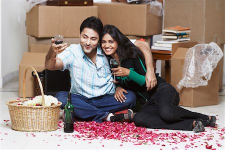 Young couple sitting on the floor holding wineglasses Stock Photo - Premium Royalty-Free, Code: 630-01076486