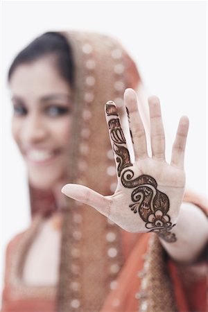 Close-up of a young woman with henna tattoo's on her hand Stock Photo - Premium Royalty-Free, Code: 630-01076934