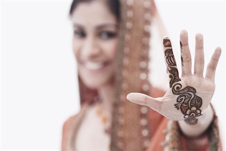 Close-up of a young woman with henna tattoo's on her hand Stock Photo - Premium Royalty-Free, Code: 630-01076935