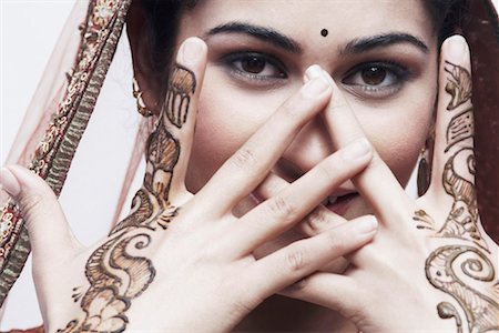 Close-up of a young woman with henna tattoo's on her hands Foto de stock - Sin royalties Premium, Código: 630-01076943