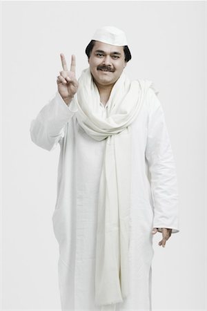 politician kurta and cap - Portrait of a male politician showing a peace sign Stock Photo - Premium Royalty-Free, Code: 630-01077093